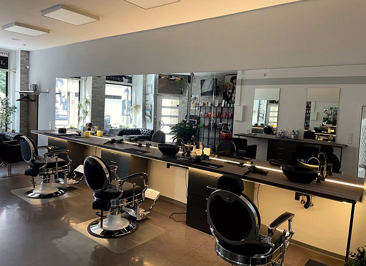 Salonraum mit Spiegelwand und Barberstühlen